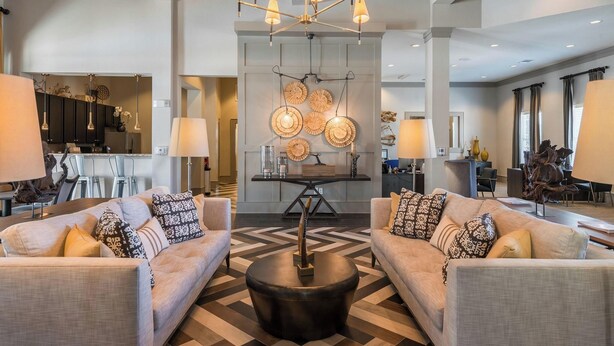 A spacious living area with two sofas, a central coffee table, and a modern chandelier.