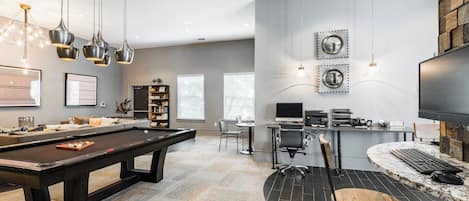 Una sala de estar moderna con mesa de billar, una zona de estar acogedora, una mesa de comedor con sillas y un espacio de trabajo con computadora y escritorio.