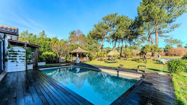 A swimming pool with a wooden deck, surrounded by trees and a gazebo. - Bed and Breakfast 'Makatea' with Shared Pool, Shared Garden and Wi-Fi (Gujan-Mestras)