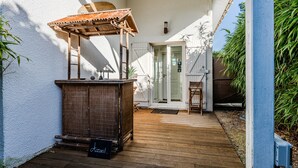 A wooden deck with a pergola, a small table, and a cabinet. - Bed and Breakfast 'Makatea' with Shared Pool, Shared Garden and Wi-Fi (Gujan-Mestras)