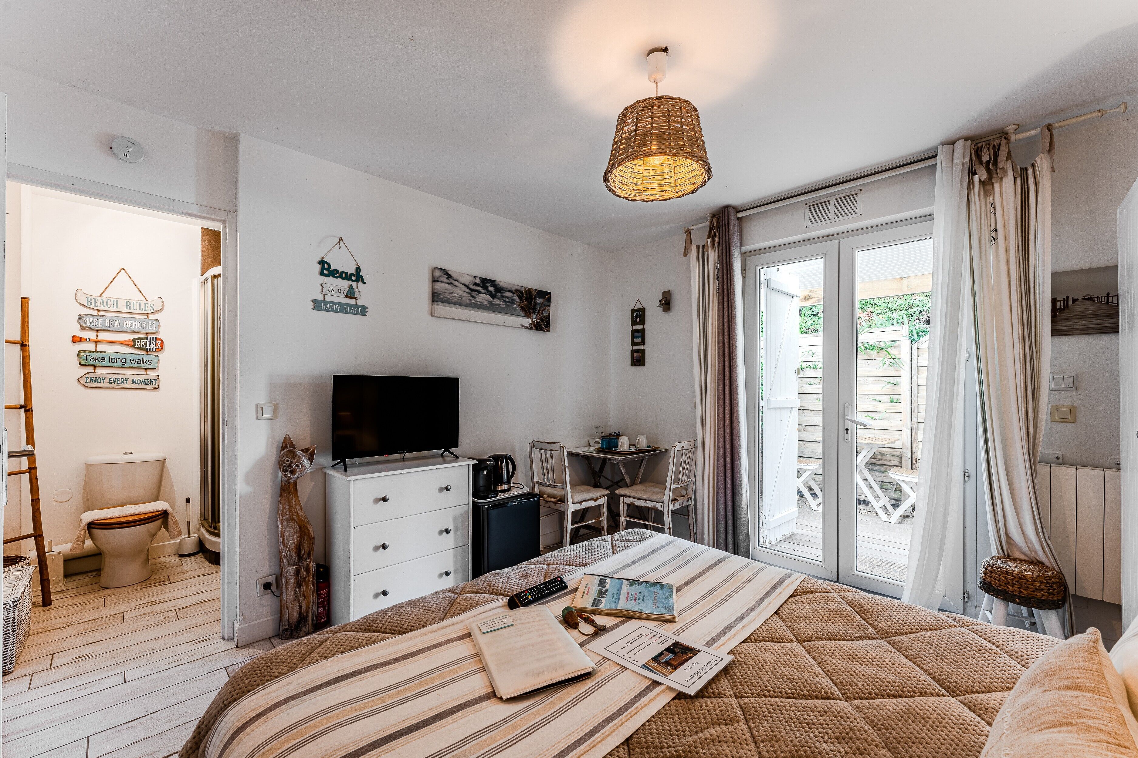 A bedroom with a bed, a television, a desk, and a chair.