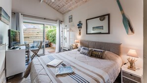 A bedroom with a bed, a desk, a chair, a ceiling fan, and a view of the outdoors. - Bed and Breakfast 'Tikeau' with Shared Pool, Private Terrace and Wi-Fi (Gujan-Mestras)