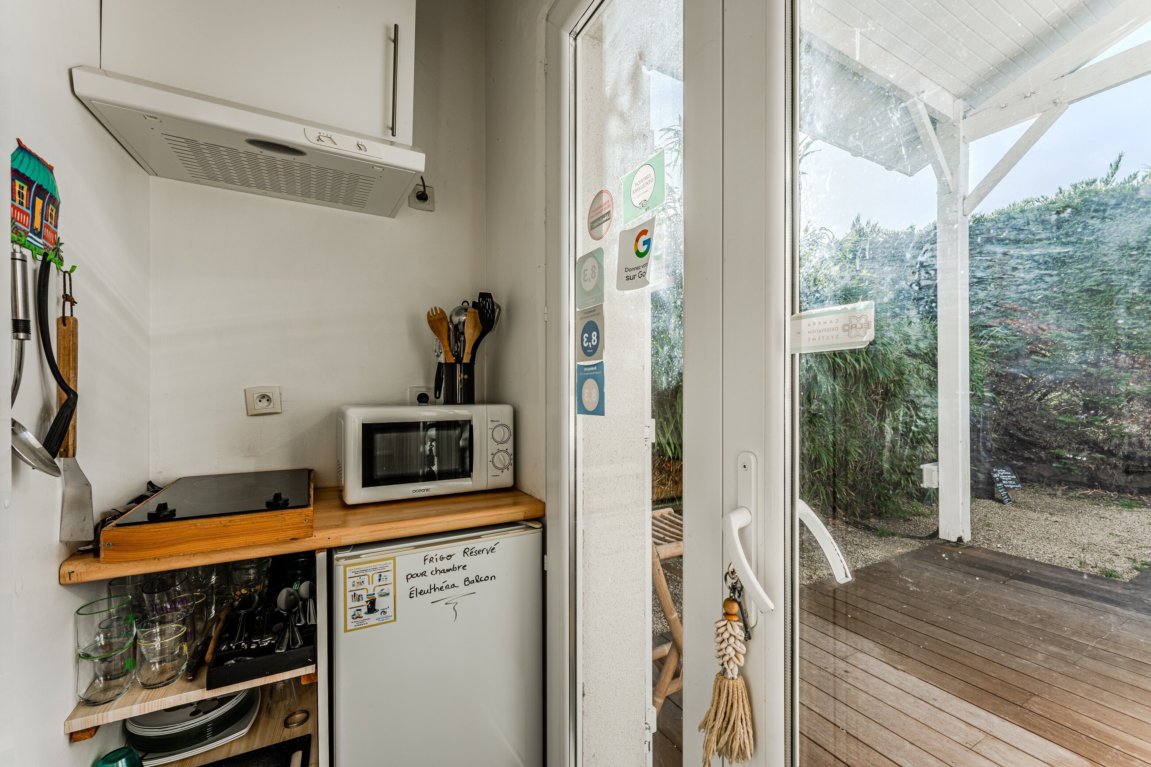 Eine kleine Küche mit einer Mikrowelle, einem Kühlschrank und einem Holzboden.