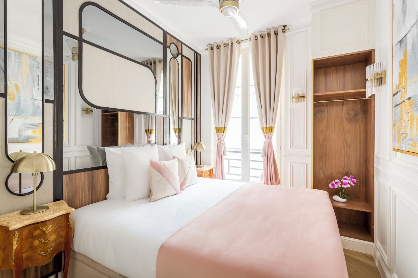 Une chambre d’hôtel avec un grand lit, une armoire en bois, une table de chevet avec une lampe et une vue sur l’extérieur.
