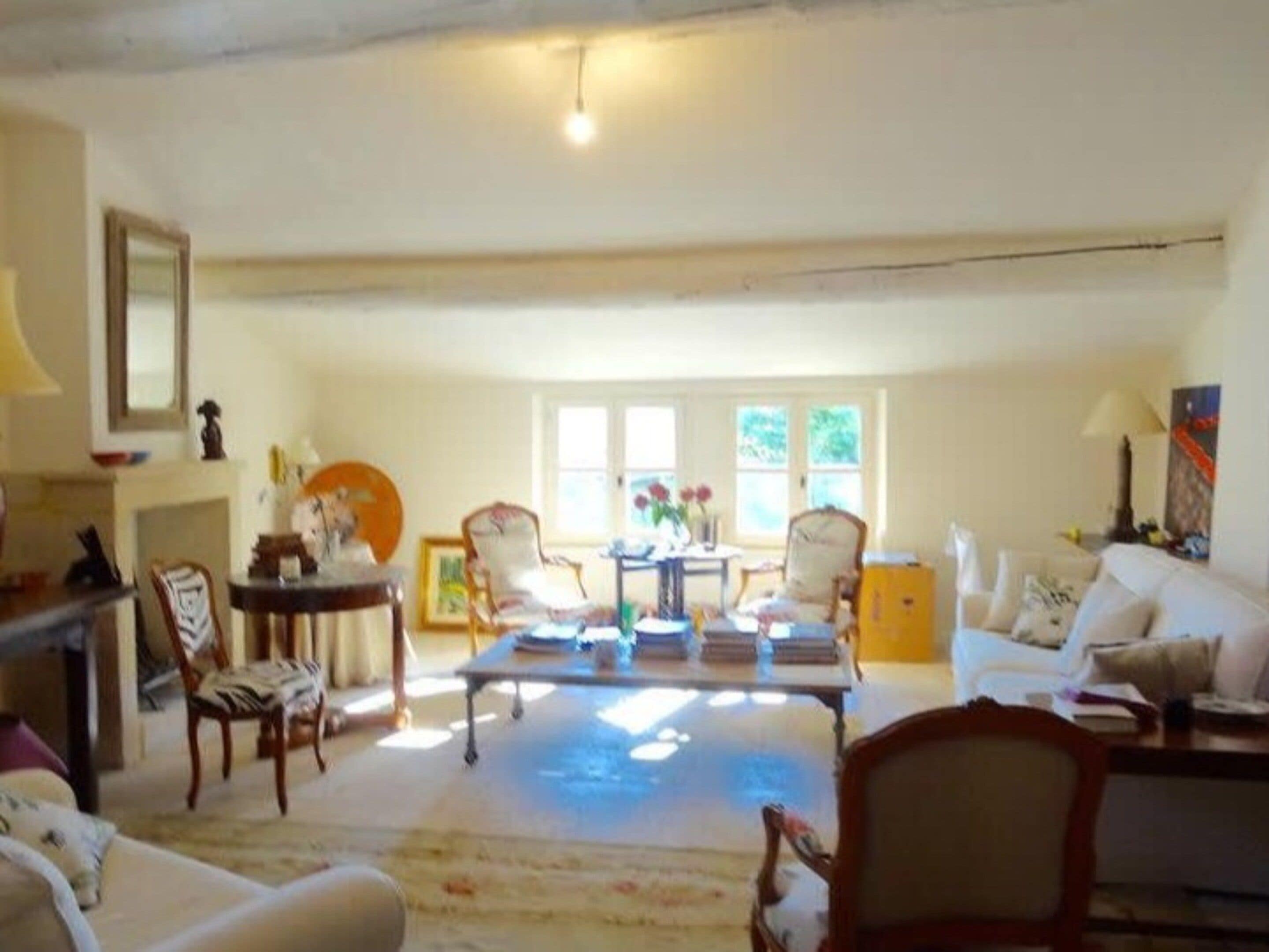 A spacious living room with a sofa, chairs, a coffee table, and a fireplace.