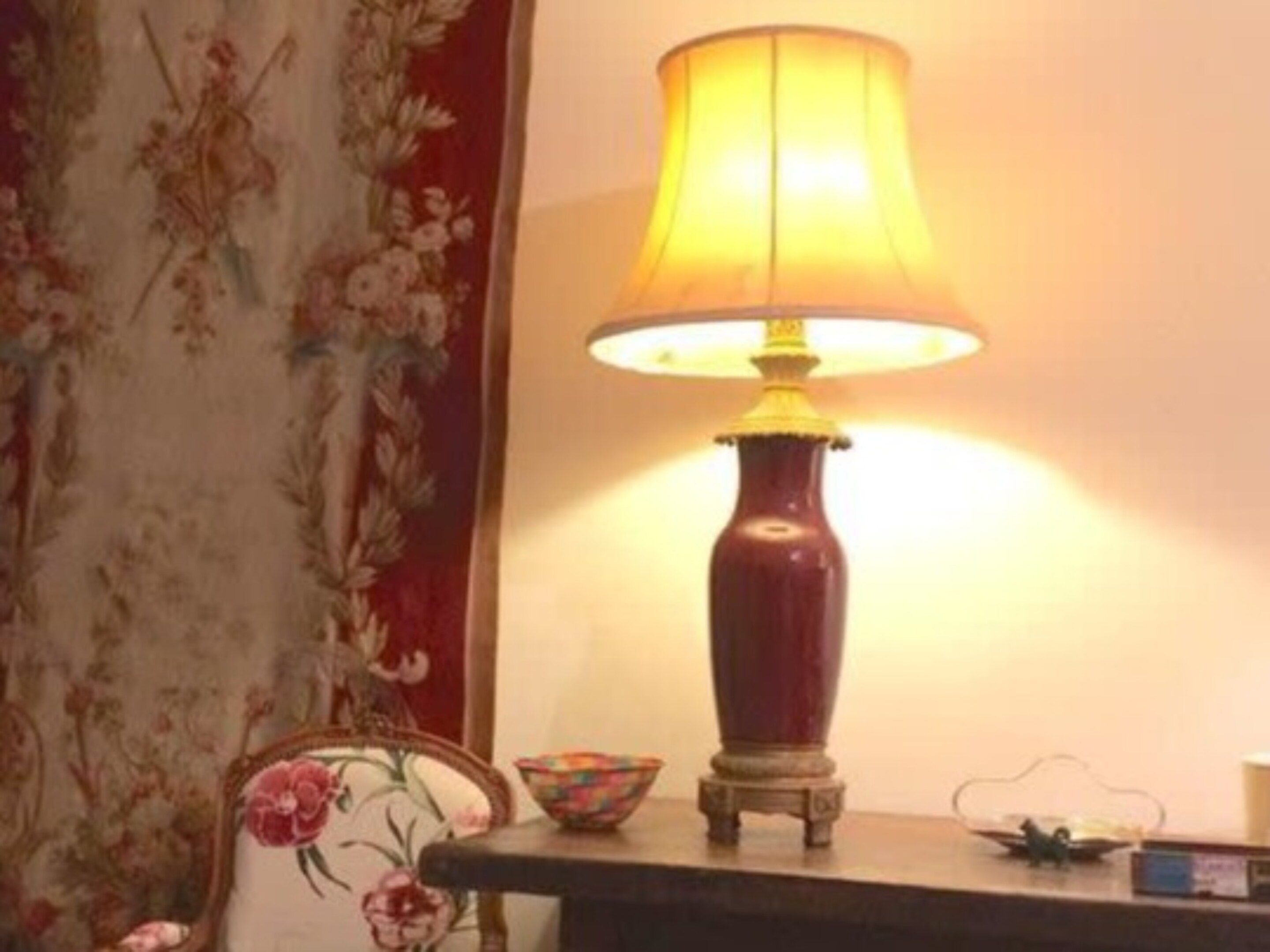 Ein Tisch mit einer Lampe, einer Schale und einem kleinen Dekorationsgegenstand.