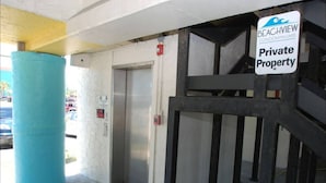 Ingresso di proprietà privata con un pilastro blu, un ascensore e un cartello che indica 'Private Property'.