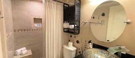 Ein Badezimmer mit Dusche, Toilette und Waschbecken.