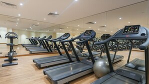 A gym with multiple treadmills, exercise balls, and weights.