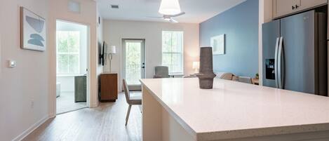 Una cocina moderna con una isla grande, electrodomésticos integrados y vistas al área de comedor.