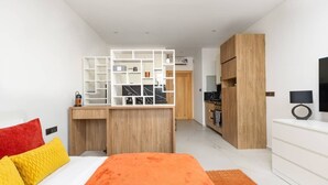 Une chambre d’hôtel moderne équipée d’un lit, d’un bureau et d’une kitchenette.