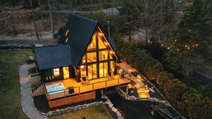 Una casa moderna con una amplia terraza, un jacuzzi y un hogar de piedra.