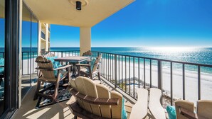 Ein Balkon mit Meerblick, ausgestattet mit Stühlen und einem Tisch.