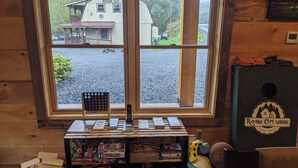 Ein Zimmer mit großem Fenster mit Blick auf einen Kiesbereich und ein Gebäude mit der Aufschrift "Rough Cut Lodge".
