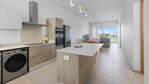 Una cocina moderna con electrodomésticos integrados, una isla central e iluminación colgante.
