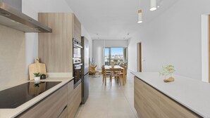 Una cocina moderna con una isla central, armarios de madera y electrodomésticos de acero inoxidable.