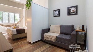 A modern living room with a grey sofa, a hammock, a bed, and a small table. - 3 Minutes From Copacabana Beach Nsc220 (Rio de Janeiro)