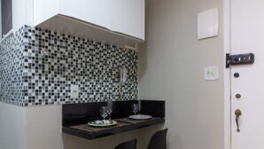 A compact kitchen with a black countertop, two black chairs, and a white door. - 3 Minutes From Copacabana Beach Nsc220 (Rio de Janeiro)