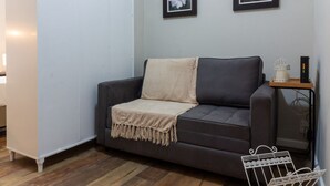A modern living room with a grey sofa, a white cabinet, and two framed floral pictures on the wall. - 3 Minutes From Copacabana Beach Nsc220 (Rio de Janeiro)