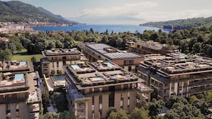 A hotel with rooftop pools, lush greenery, and a scenic view of the sea. - Falkensteiner Resort Lake Garda (Salò)