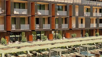 Un hotel con varios balcones, mobiliario exterior y una piscina.