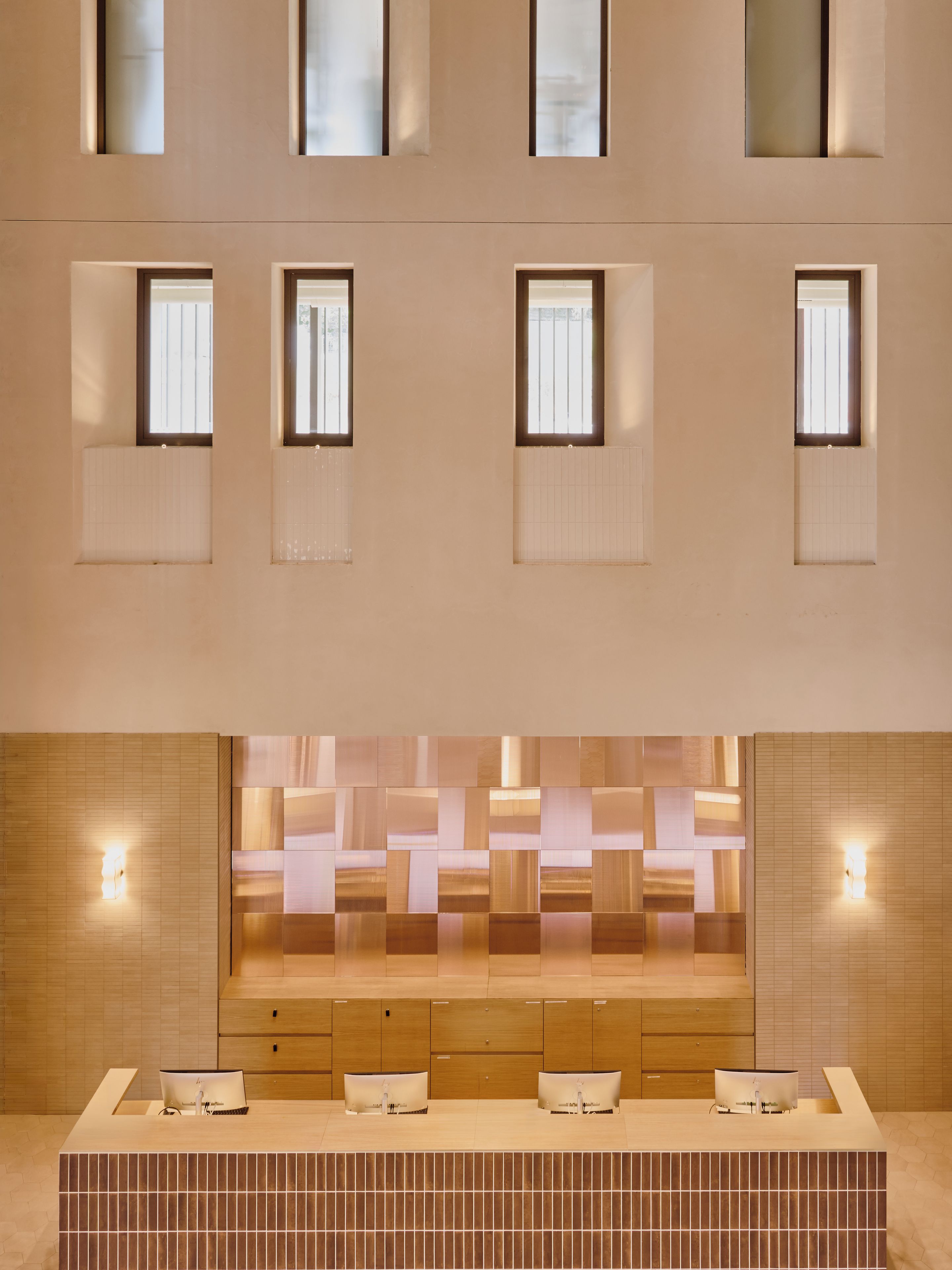 Un baño moderno con un espejo grande, varios lavamanos e iluminación empotrada.