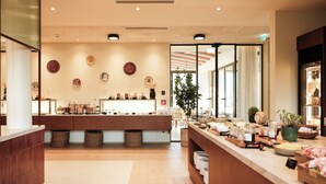 Un interior moderno con un mostrador de recepción, una planta y una barra con diversos objetos.