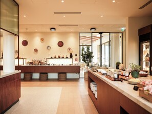 A modern interior with a reception desk, a plant, and a counter with various items. - Falkensteiner Resort Lake Garda (Salò)