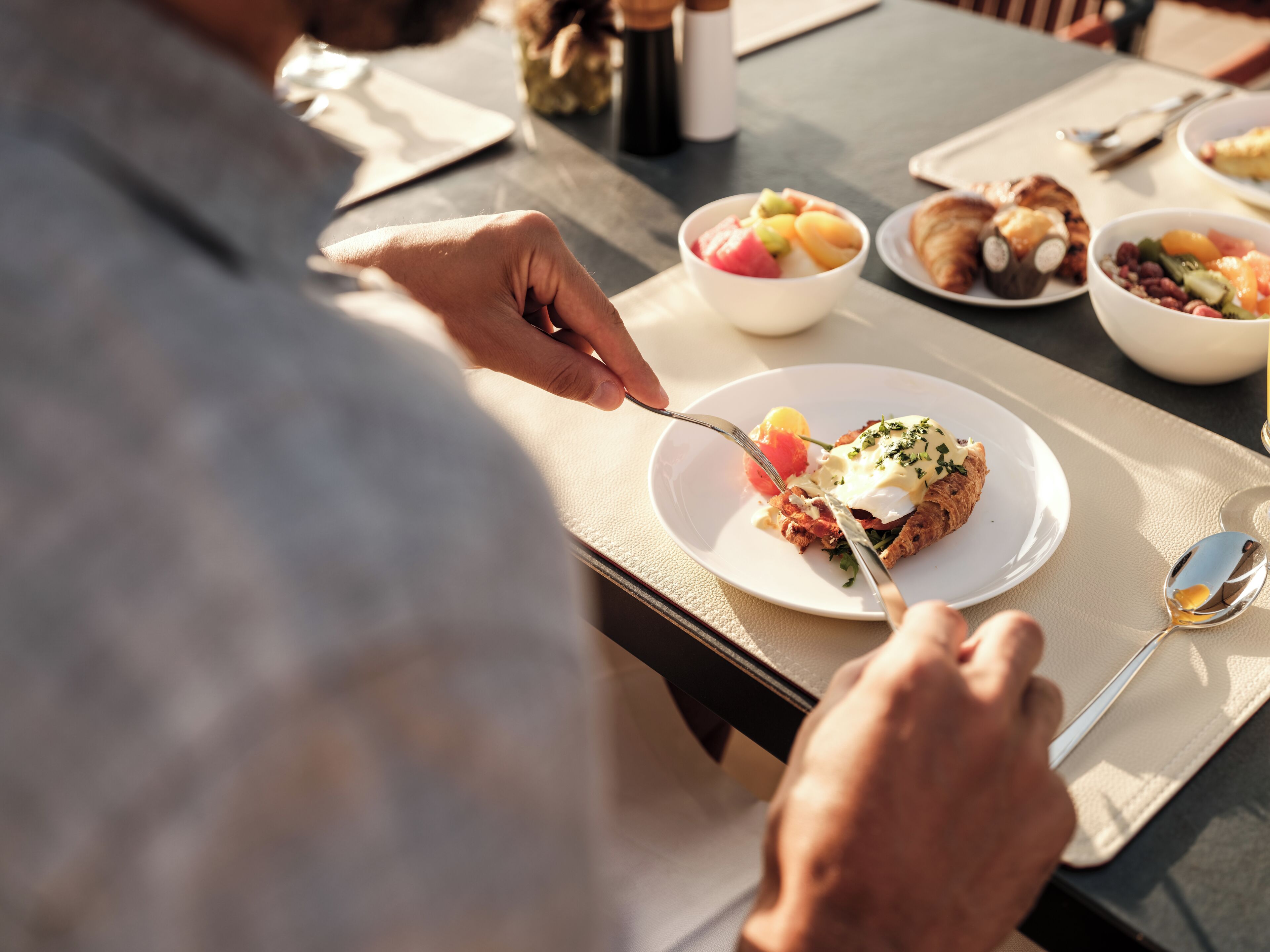 Une table à manger avec des assiettes remplies de nourriture, une bouteille et une cuillère.