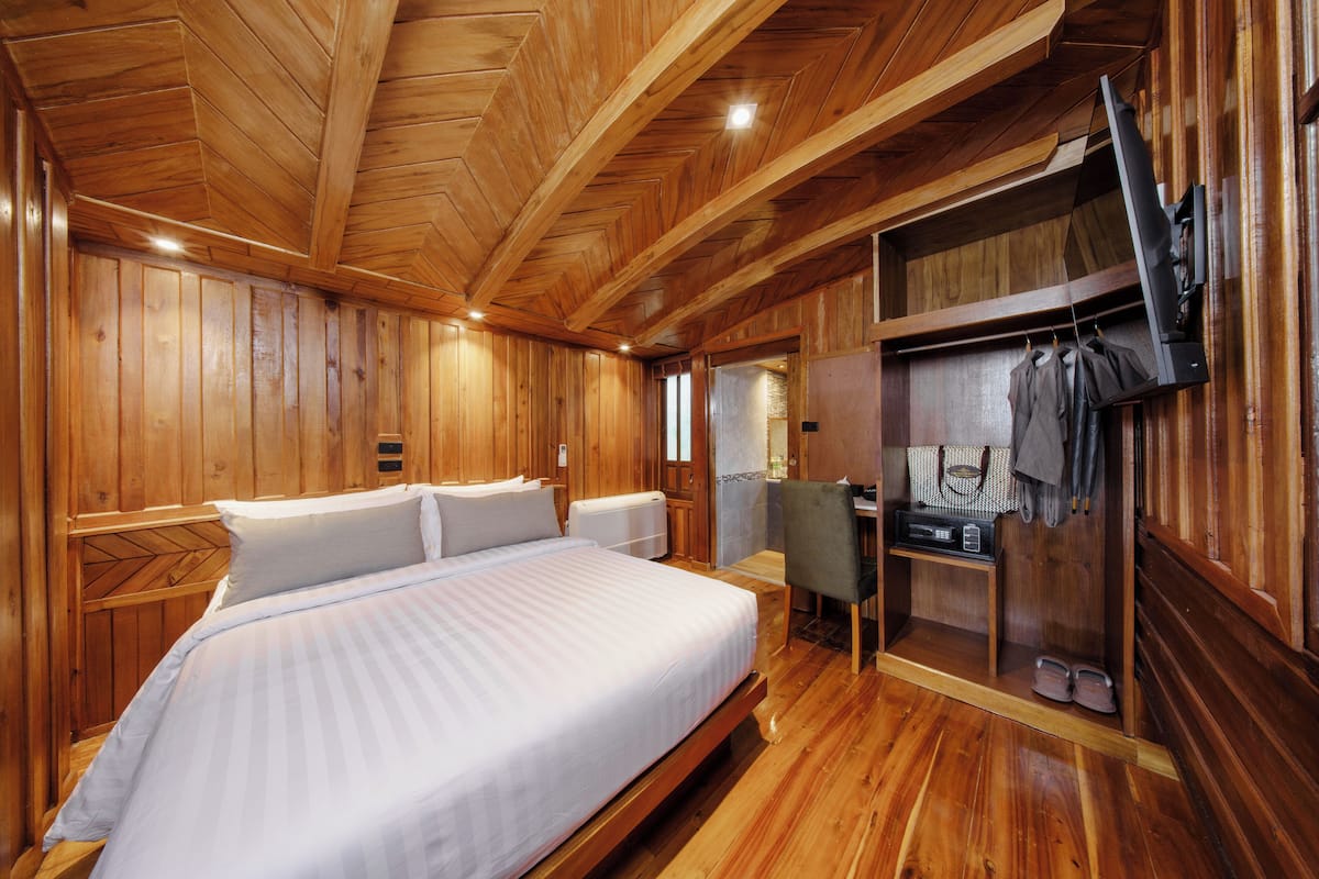 Een kamer met houten lambrisering, een bed, een bureau en een inloopkast.