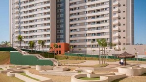 A high-rise residential building with a landscaped garden featuring circular planters and a staircase leading to the upper levels. - RESORT: 2 adultos e 1 criança a 4km do Thermas Lar. e a 3km do Hot Beach (Olímpia)