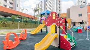 A playground with slides and climbing structures, surrounded by buildings and palm trees. - RESORT: 2 adultos e 1 criança a 4km do Thermas Lar. e a 3km do Hot Beach (Olímpia)