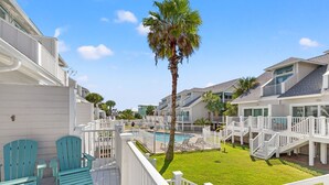 Ein Resort mit Pool, Sitzgelegenheiten im Freien und einem weißen Zaun.