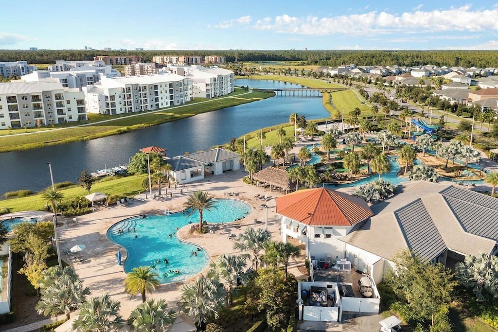 A resort with multiple swimming pools, a golf course, and a river.