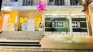 A multi-story hotel with balconies, flags, and a storefront. - Résidence hôtelière Samba (Douala)