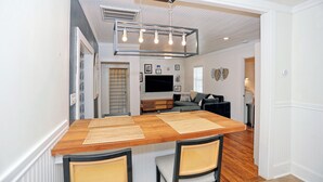 Un coin repas avec une table en bois, quatre chaises et un luminaire suspendu.