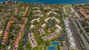 An aerial view of a residential area with multiple apartment buildings, roads, and green spaces.