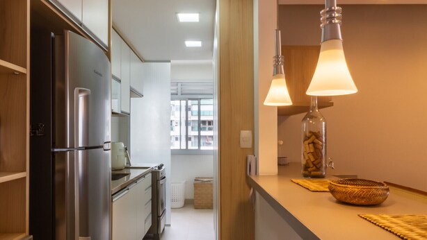 A modern kitchen with a built-in refrigerator, a countertop with a basket, and pendant lights. - 10 Minutes From the Olympic Park Pja802 (Rio de Janeiro)