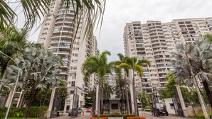 A multi-story residential building with balconies, surrounded by palm trees and a gated entrance. - 10 Minutes From the Olympic Park Pja802 (Rio de Janeiro)