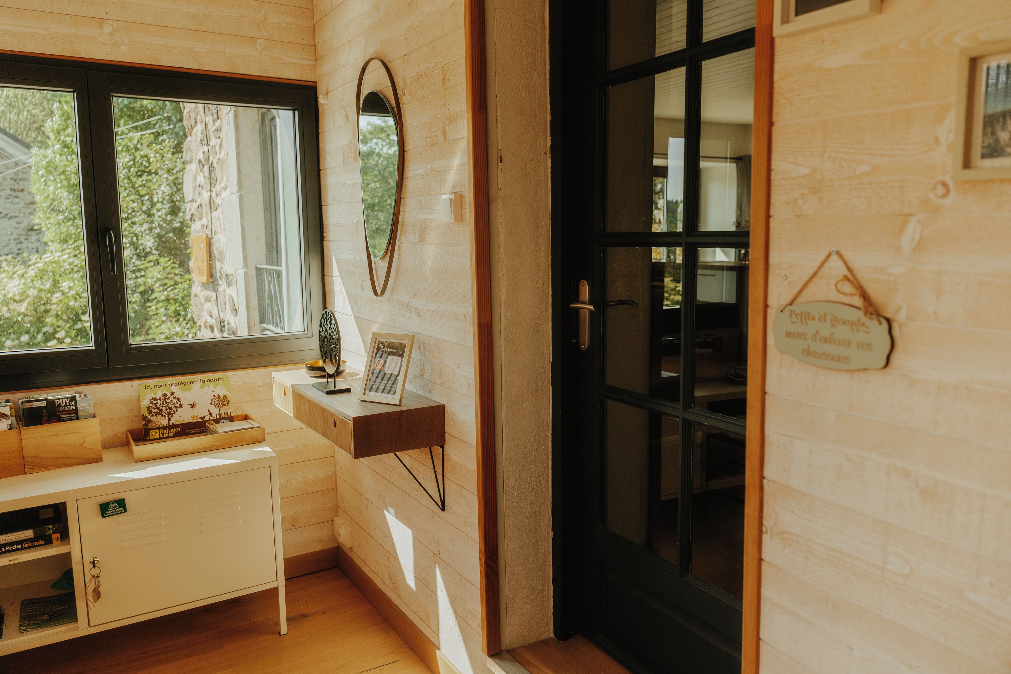 Une pièce avec un intérieur en bois, une fenêtre, une porte et une petite table sur laquelle se trouvent divers objets.