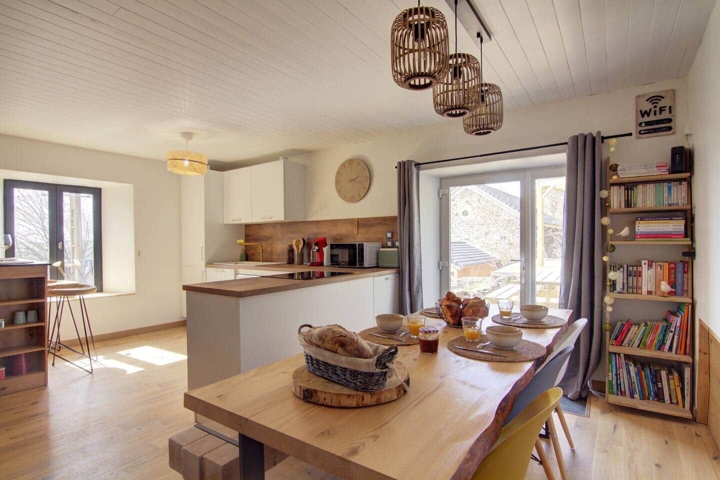 Een moderne keuken met een centraal eiland, houten vloeren en een boekenplank vol boeken.