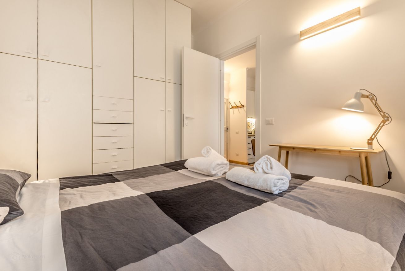 Ein Schlafzimmer mit Bett, Schreibtisch und Kleiderschrank.