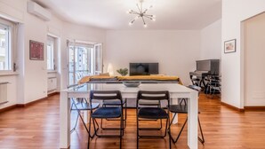 Una cocina moderna con una mesa de comedor, sillas y un televisor.