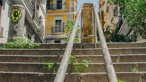 A set of concrete stairs with metal handrails, leading up to a building with balconies and windows. - MIMI HOUSE IN THE HISTORIC CENTRE (Naples)