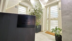 A reception area with a sign reading "Dimora da Vitoria," a potted plant, and a door with a frosted glass panel. - House in the heart of the historic center of Naples - Small Apartment (Napoli)