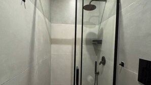 A glass-enclosed shower with a handheld showerhead and a wall-mounted control panel. - House in the heart of the historic center of Naples - Small Apartment (Napoli)
