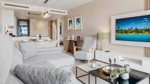 Un salon moderne avec un canapé, une table basse et un téléviseur fixé au mur.