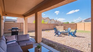 An outdoor patio with a sofa, grill, and chairs. - Sleeps 20! Movie Theater, Arcade & King Suites near Stadium (Glendale)
