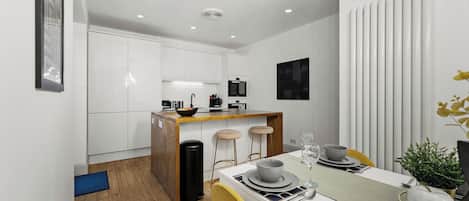 A modern kitchen with white cabinets, a wooden island, and a dining area with a table set for two.