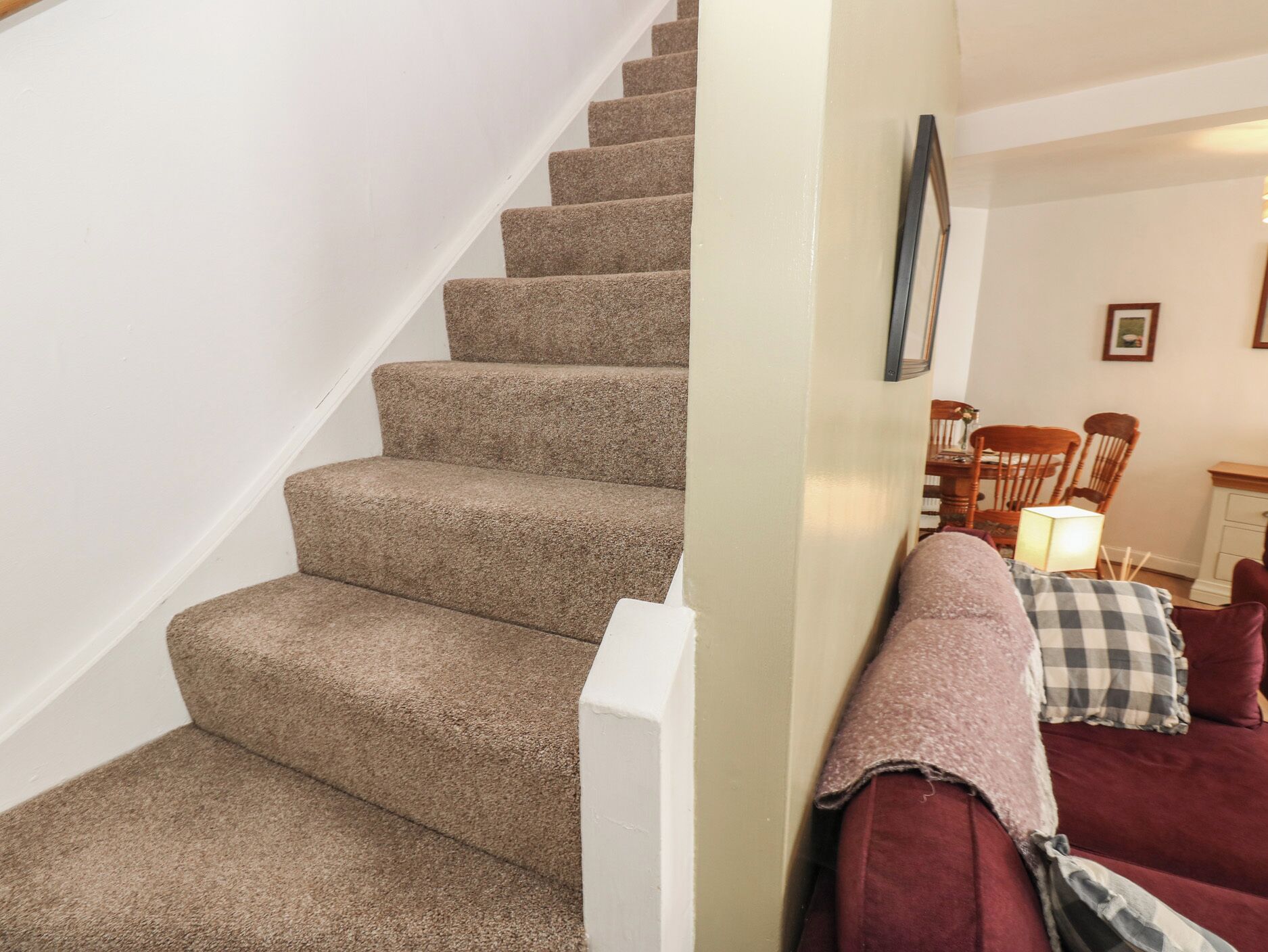 A staircase with carpeted steps leading to a landing.